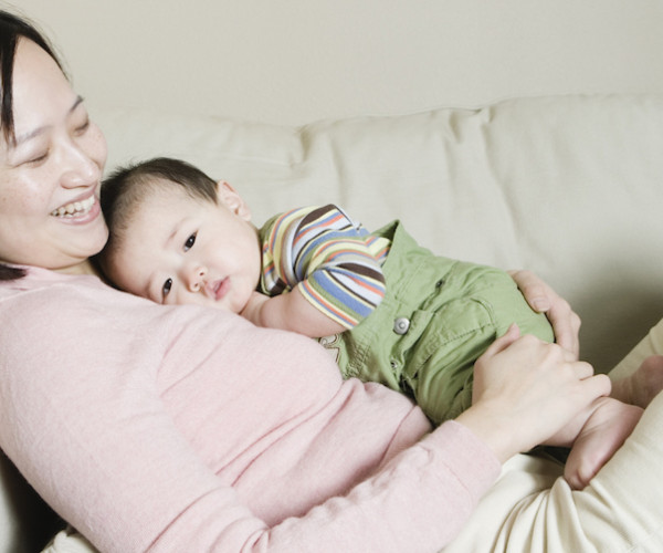 Woman and baby snuggling on couch