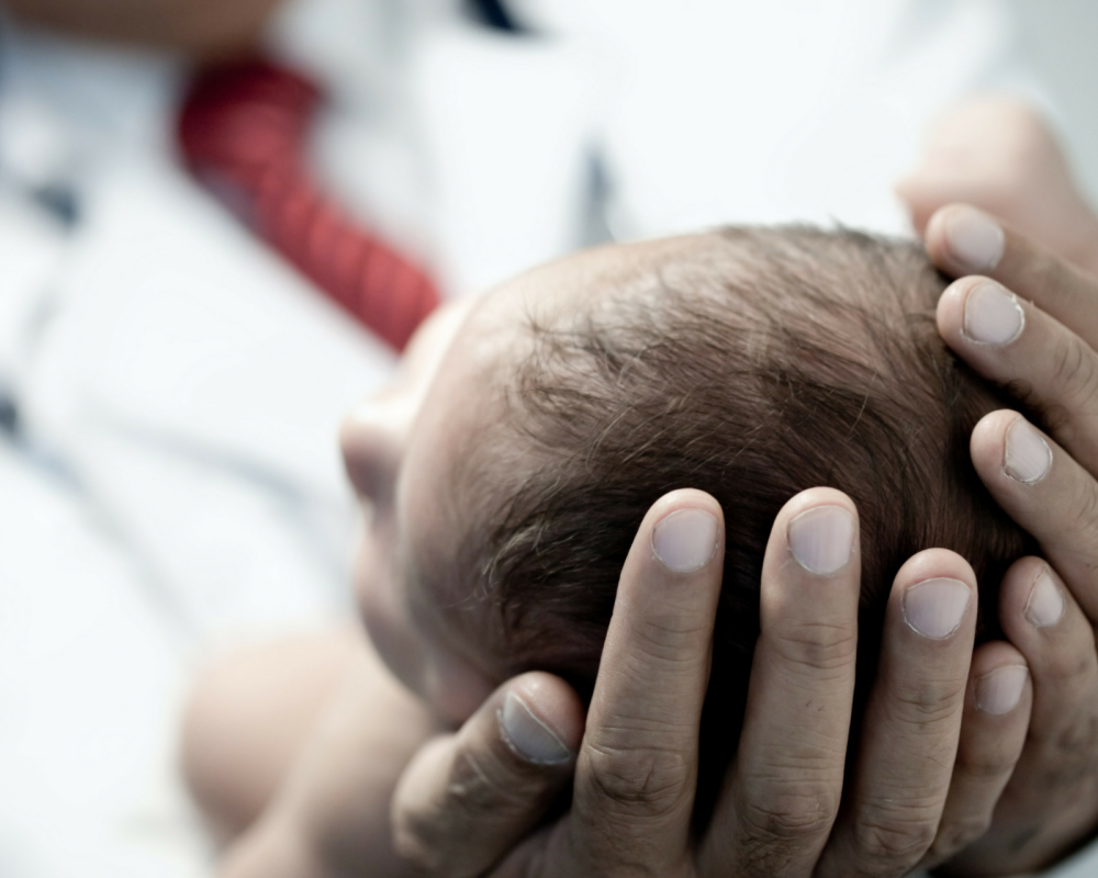 Hands cradling a newborn baby