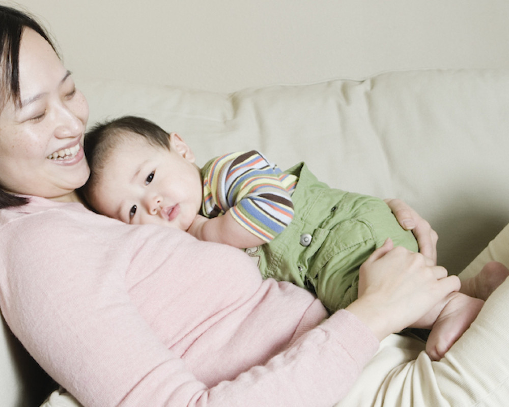 Woman and baby snuggling on couch