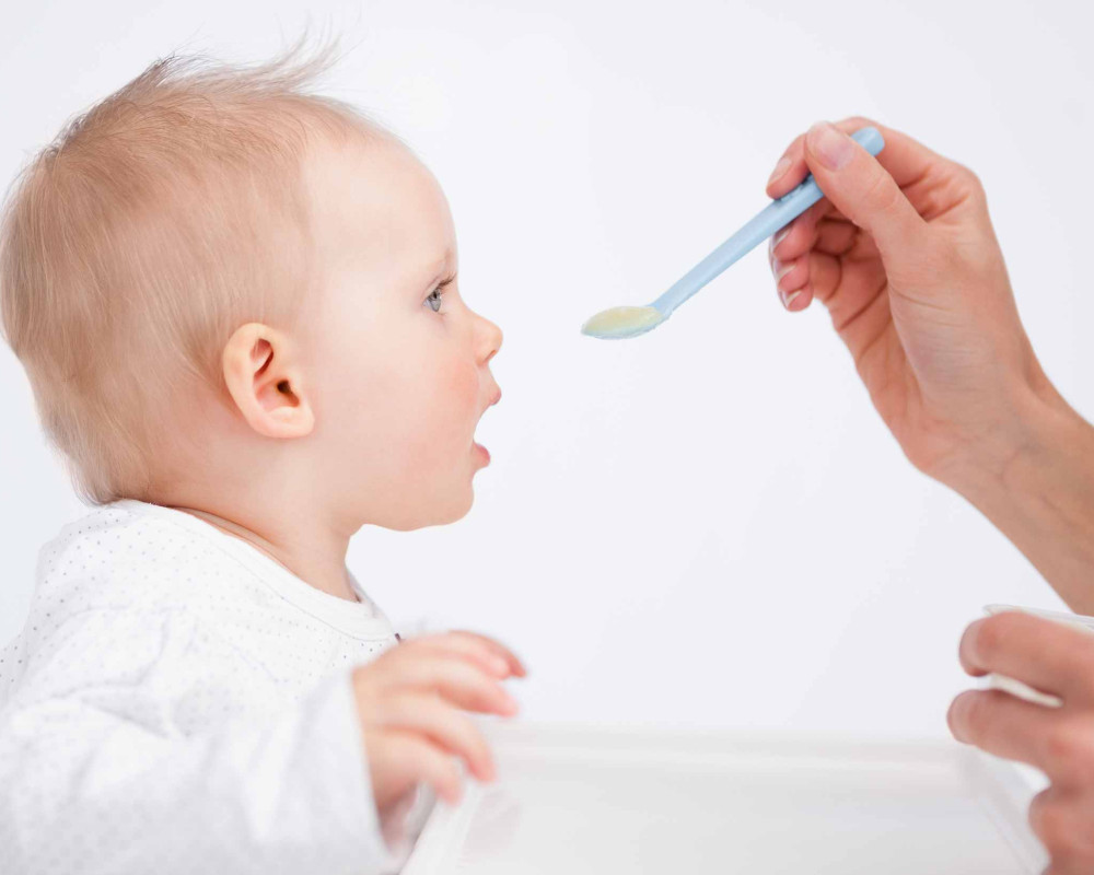 baby being fed cereal