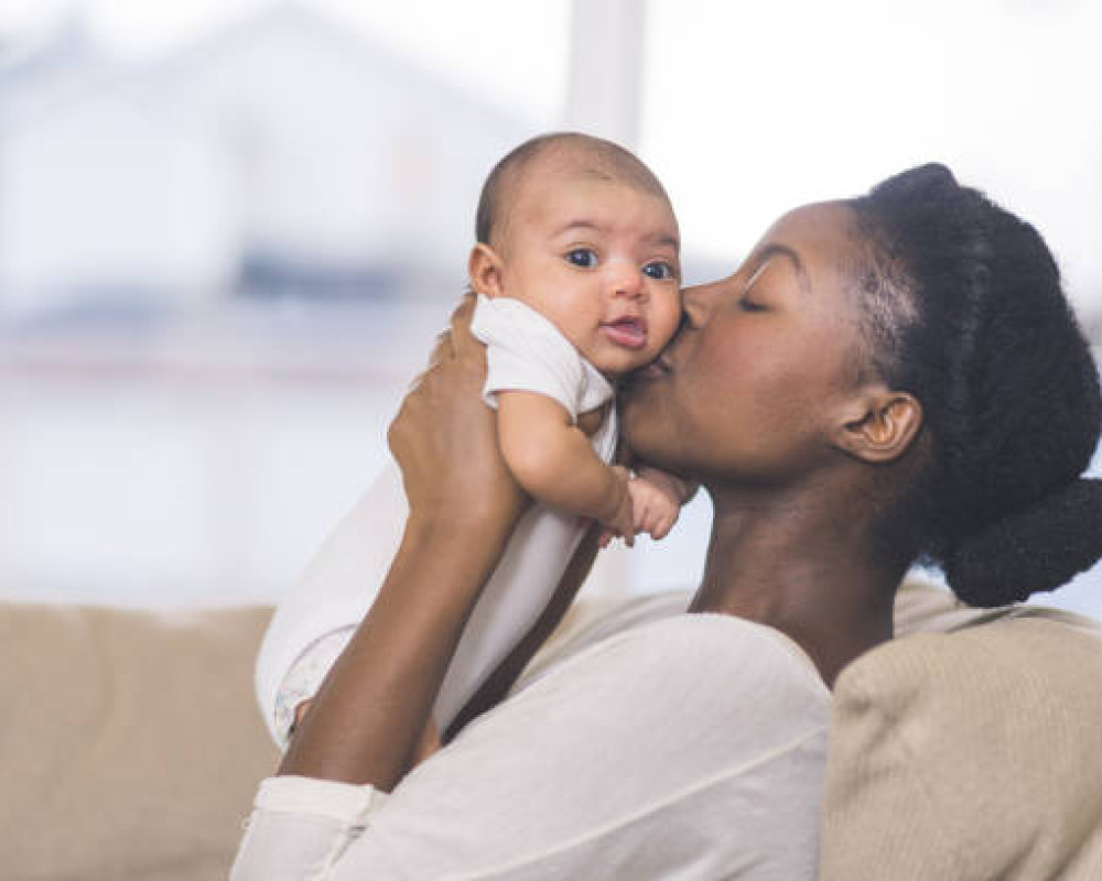 Mom kissing newborn